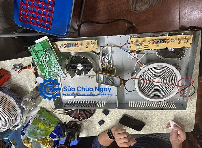 Kỹ thuật viên kiểm tra bo mạch bếp từ bằng thiết bị chuyên dụng tại Hoàng Mai.